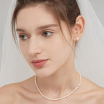 STMG Pearl Stud Earrings on ear with pearl necklace on neck