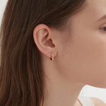 STMG Irregular Twisted Circle Hoops in gold on ear