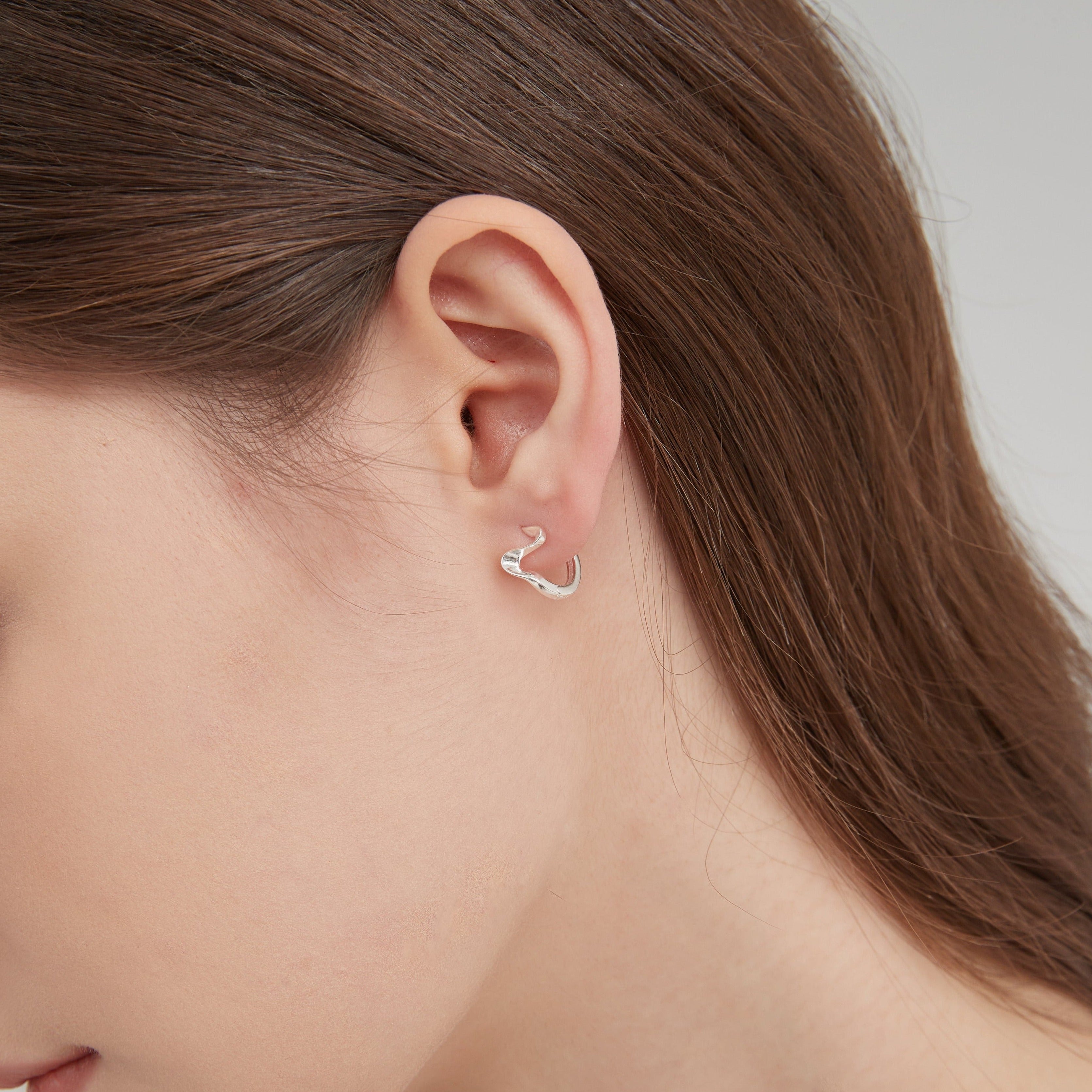 STMG Geometric Wave Hoops in silver on ear