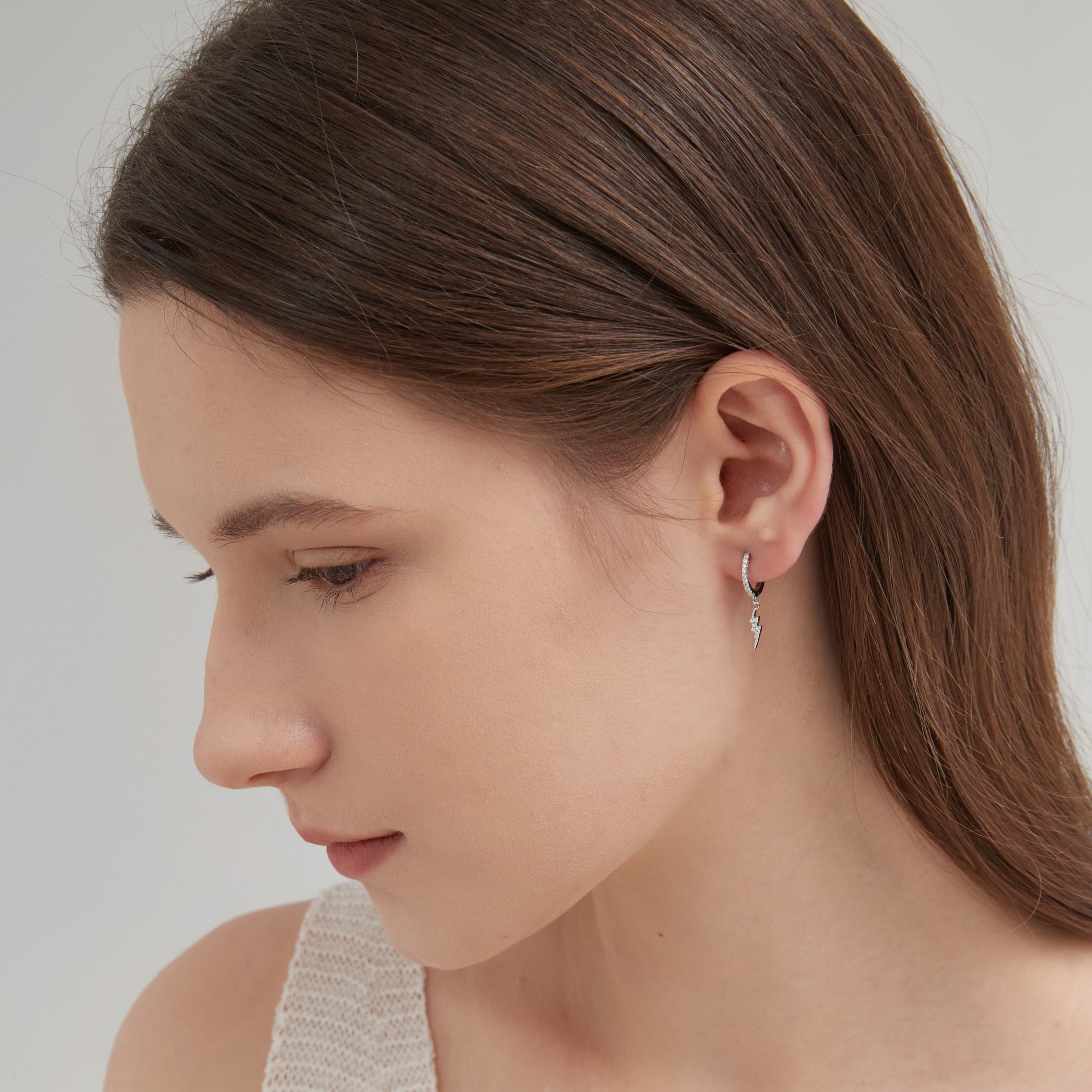 STMG Lightning Bolt Dangle Hoops in silver on ear