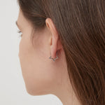 Geometric Star Hoops in silver on ear