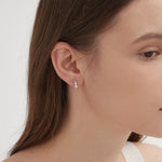 Curved Tiny Stud Earrings in silver on ear