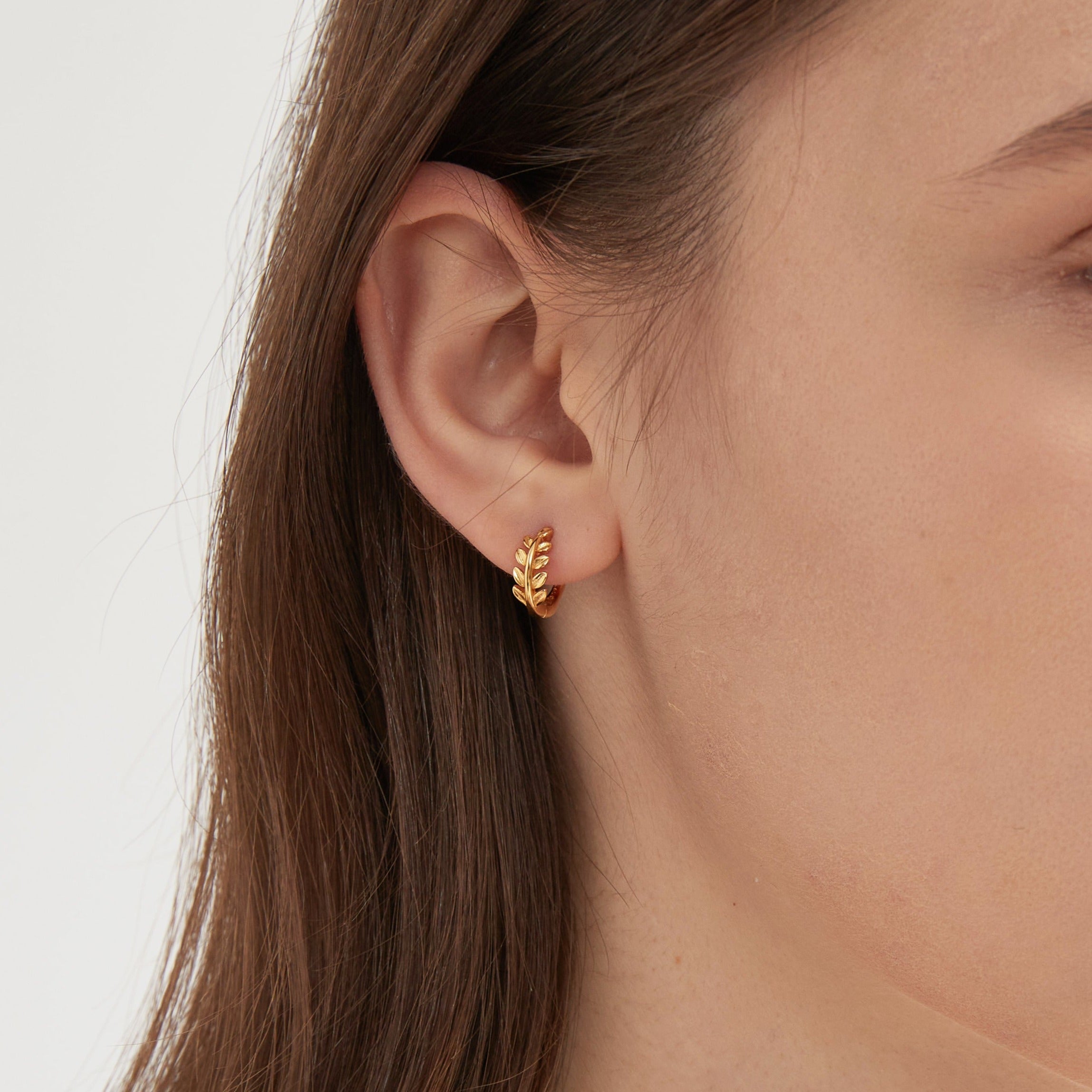 STMG Tiny Olive Leaf Hoops in gold on ear