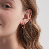 Geometric Cross Hoops in gold and rose gold on ear