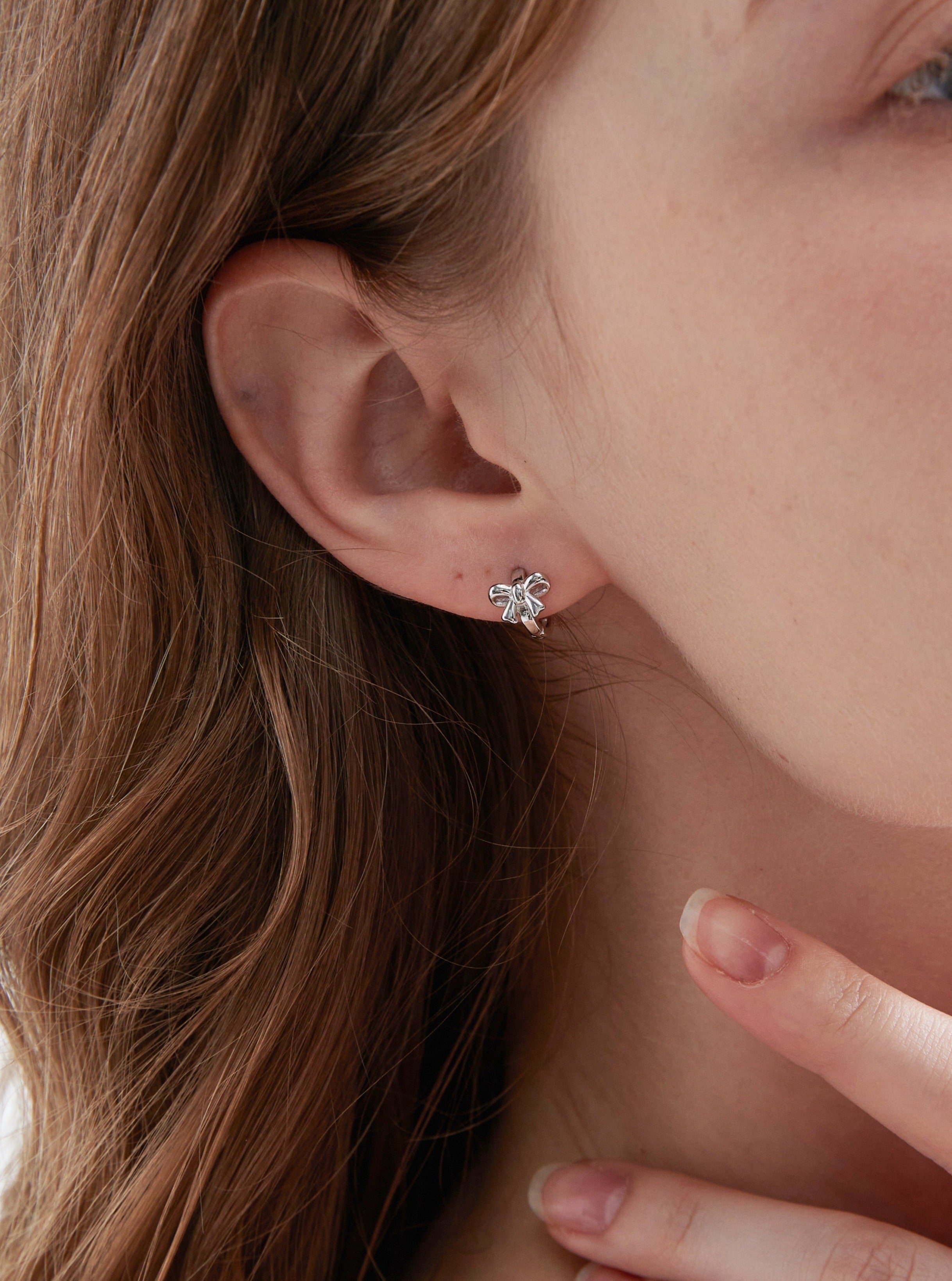 STMG Minimalist Bowknot Hoops in silver on ear