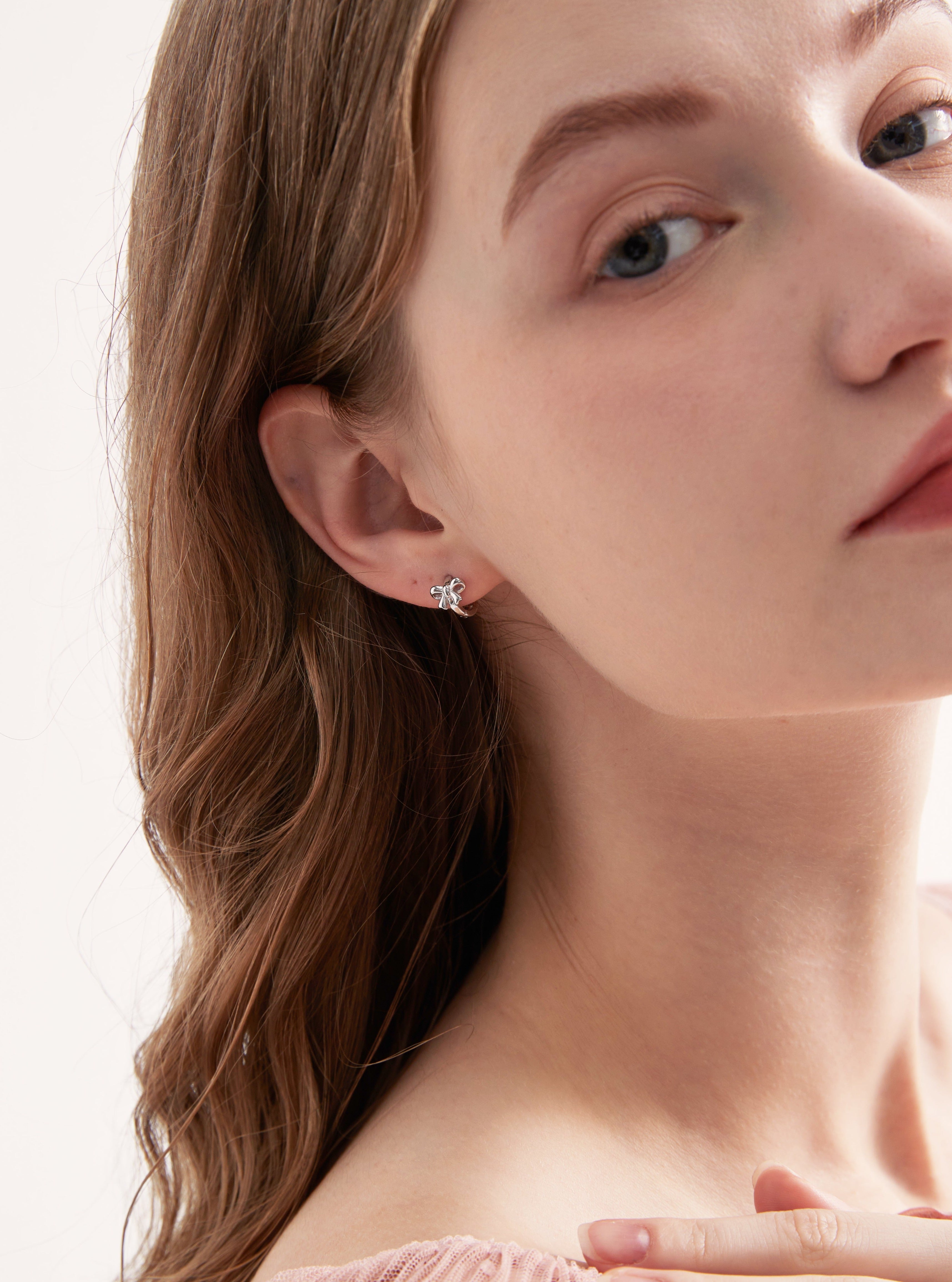 STMG Minimalist Bowknot Hoops in silver on ear