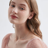 STMG Tiny Daisy Stud Earrings on ear with matching necklace on neck