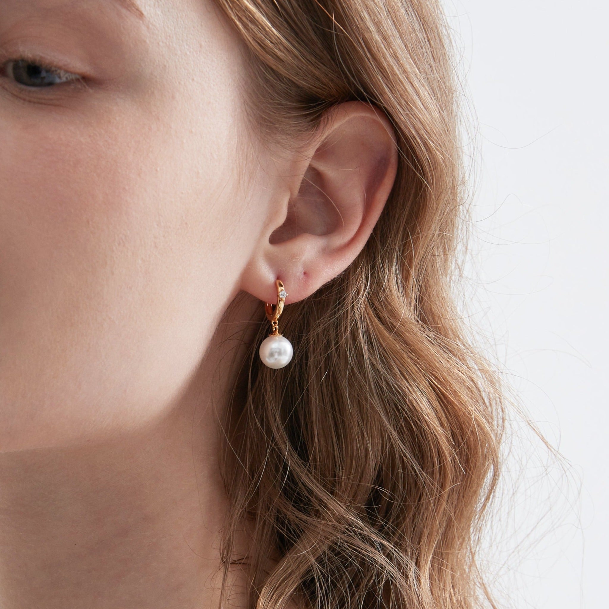 STMG Pearl Dangle Hoops in gold on ear