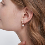 STMG Minimalist Pearl Hoops in champagne gold on ear