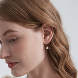 STMG Pearl Dangle Earrings in gold on ear