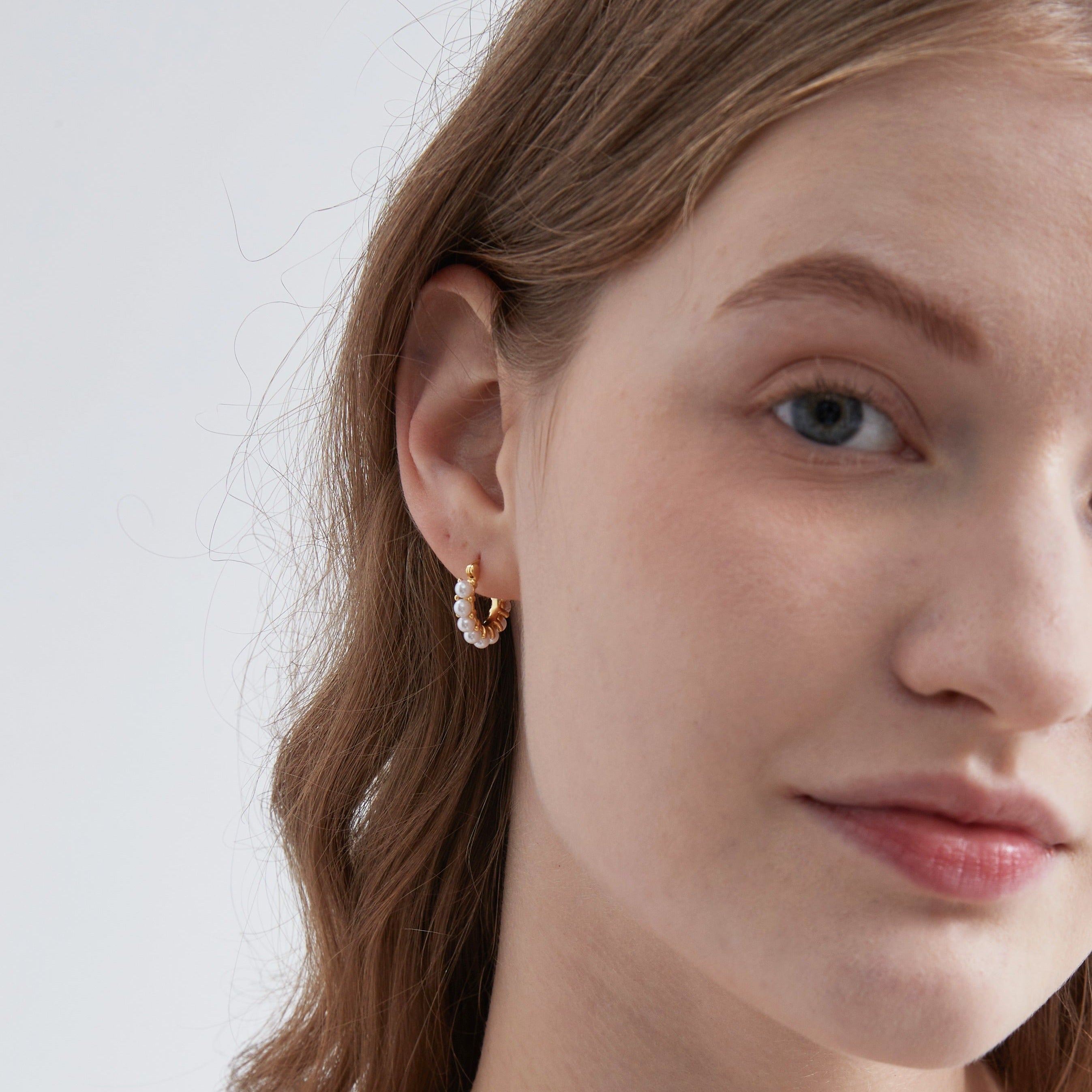 STMG Minimalist Pearl Hoops in gold on ear