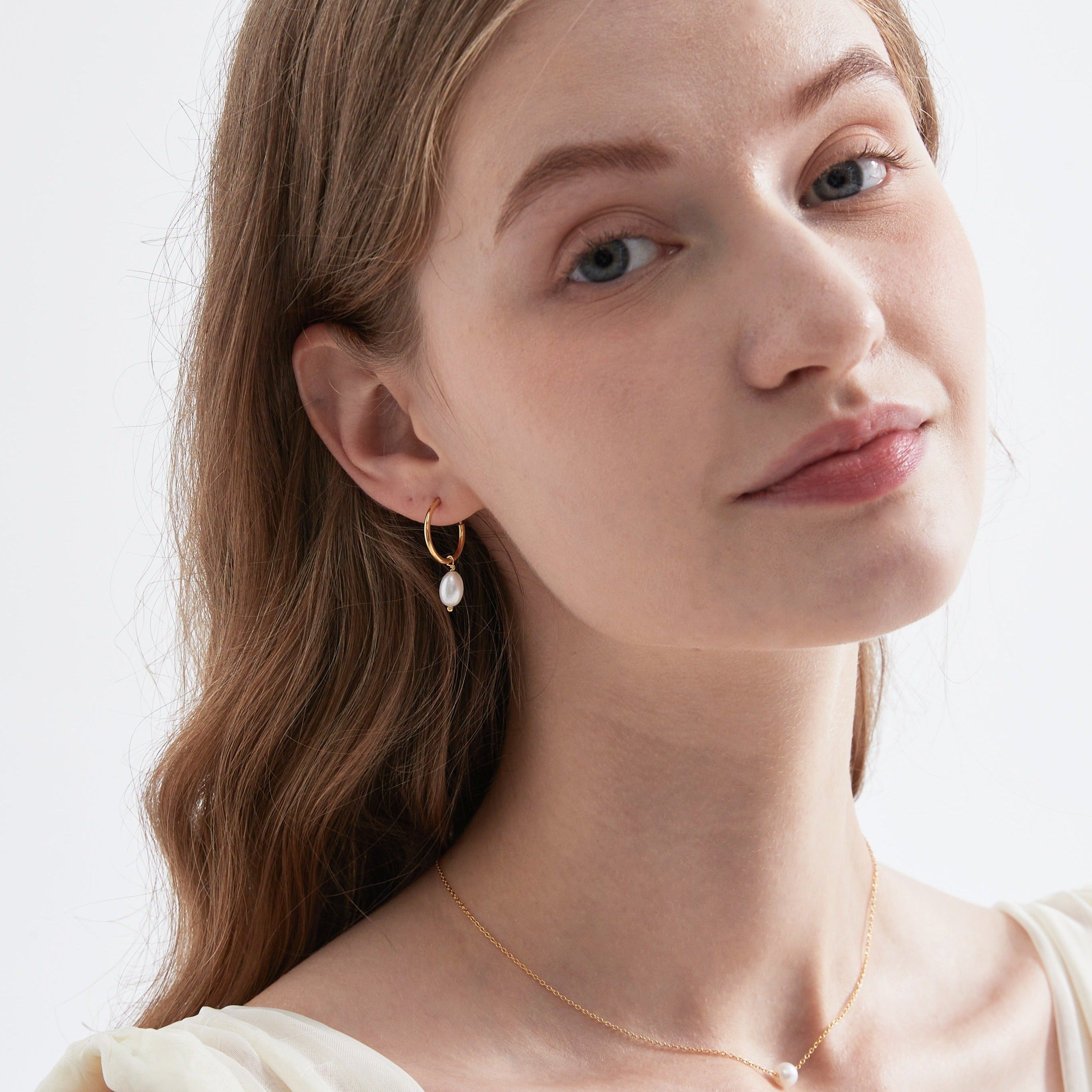 STMG Natural Pearl Dangle Hoops in gold on ear