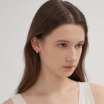 Angel Wing Hoops in gold on ear