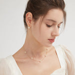 STMG Pearl Daisy Dangle Earrings in gold on ear with matching necklace on neck