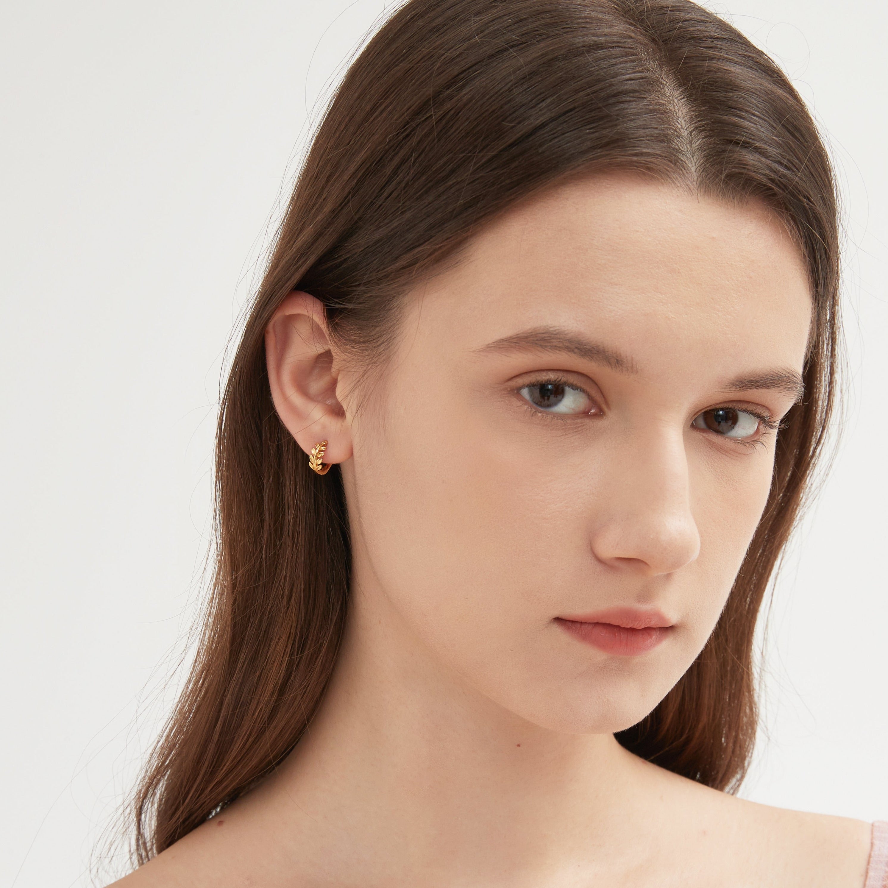 STMG Tiny Olive Leaf Hoops in gold on ear